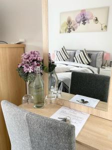 曼彻斯特Bridgewater House - Private Room & Bathroom Near Etihad and CoOp Arena的一张桌子,上面放着一瓶水和鲜花