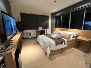 巴科洛德The UpperRoom @ Real Suites的一间卧室配有一张大床和一台平面电视