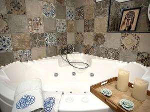 亚眠Appartement cosy hyper-centre 70m2的浴室配有带2把蜡烛和毛巾的浴缸。