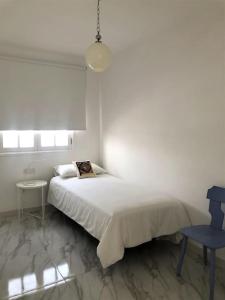 宏达海滩Casa Nicolás的白色卧室配有床和蓝椅
