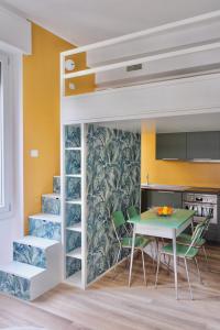 米兰La Maison City Life Apartments的厨房配有一张高架床,配有桌椅