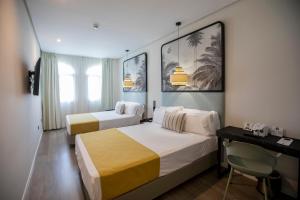 圣玛丽亚港港口索霍精品酒店的酒店客房配有两张床和一张书桌