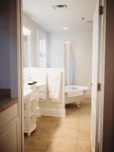 南派恩斯The Jefferson Inn的白色的浴室设有浴缸、水槽和卫生间。
