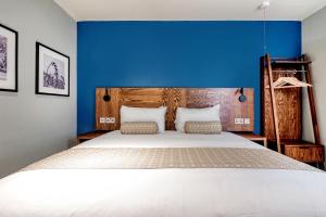 沃金The Wheatsheaf by Innkeeper's Collection的一间卧室设有一张蓝色墙壁的大床