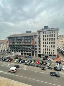米兰NEW LUXURY STUNNING BILO APARTMENT IN THE HEART OF MILAN MOSCOVA的大型建筑前的停车场,有车辆停放