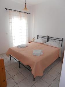 考弗尼西亚Glaros Rooms的一间卧室配有一张带橙色毯子的大床