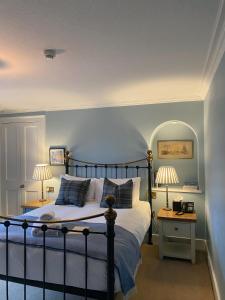 Mintlaw赛普琳布瑞酒店的一间卧室配有一张蓝色墙壁的床和两盏灯。