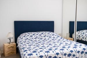 Saint-Étienne-de-LisseMaison au coeur du vignoble de Saint-Emilion的一间卧室配有一张带蓝色和白色棉被的床