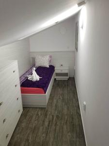 丘斯滕迪尔Red House的一间小卧室,配有一张带紫色床垫的床