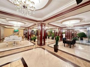 巴库Modern Hotel的一个带钢琴和桌子的大型大堂