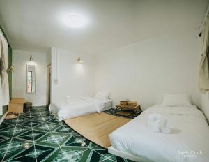 Ban MakokBaannok cottages Lamphun的客房设有两张床,铺有绿色瓷砖地板。