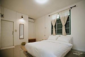 Ban MakokBaannok cottages Lamphun的卧室设有一张白色大床和一扇窗户。