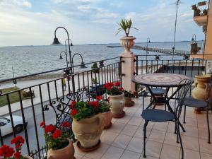 莱西纳L'ISOLA AeR B&B的一个带桌椅的海景阳台