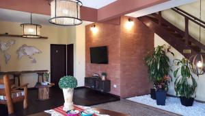 维拉卡洛斯帕兹米拉多尔代拉斯山脉酒店的客厅配有盆栽植物和电视