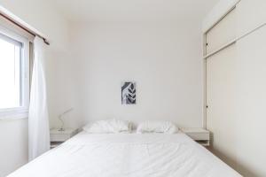 布宜诺斯艾利斯Apart amplio Palermo chico的卧室内的一张带两个枕头的白色床