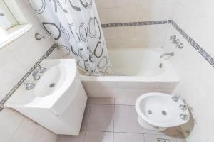 布宜诺斯艾利斯Apart amplio Palermo chico的白色的浴室设有浴缸、水槽和卫生间。
