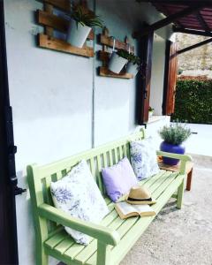 Appartamento Lavanda - Casa vacanza nel Delta del Po的庭院内带枕头和书籍的绿色长凳