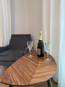 皮什Leśna Residence & SPA的木桌旁的一瓶香槟和两杯酒