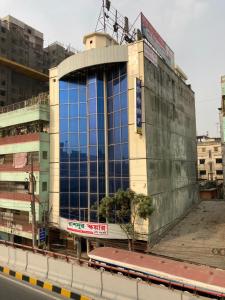 达卡Hotel Shahin Residential Jatrabari的街道边的建筑,有蓝色的窗户