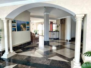 巴尔巴特Hotel Playa del Carmen的走廊上设有柱子,铺有黑白瓷砖地板。
