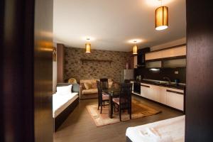 桑丹斯基SPA Apartments Perun的厨房以及带桌子和沙发的客厅。