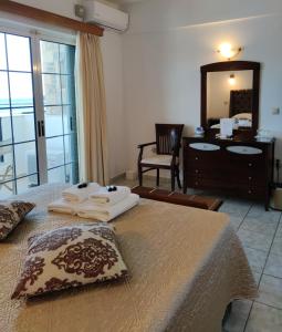 莫奈姆瓦夏菲罗斯尼亚酒店的一间卧室配有一张床、梳妆台和镜子