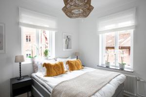 哥德堡WOW, Föreningsgatan 9的白色卧室配有一张带黄色枕头的大床