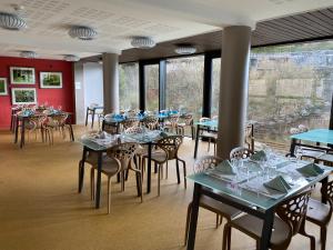 鲁瓦昂地区蓬水音乐酒店的用餐室设有桌椅和窗户。