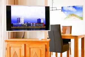 库克斯港Haus Horizont H513的一间房间,配有一张桌子和一台墙上的电视