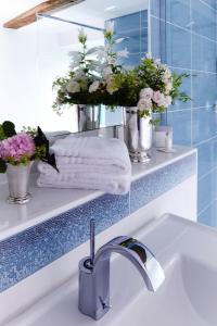 黑塞罗德罗曼蒂克罗森霍夫酒店的浴室设有水槽、镜子和鲜花