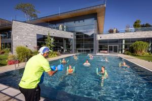 布鲁克安德格罗斯哥Woferlgut - Wellness & Sport的站在水里的人的游泳池里的人