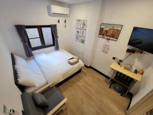 龙潭OLD WOW老屋瓦共享民宿Hostel 桃園市民宿074號的一间小卧室,配有一张床和电视