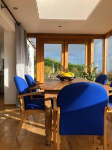HirnantTranquil 3-Bed Cottage Near Lake Vyrnwy的一间带木桌和蓝色椅子的用餐室