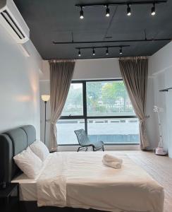八打灵再也Geo Suite - Sunway Pyramid & Sunway Lagoon的一间卧室配有一张床、一把椅子和一个大窗户