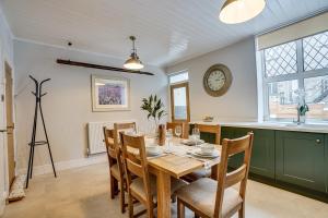 巴克斯顿Sage Cottage: Homely, Cosy Cottage with Log Burner的一间带桌椅和时钟的用餐室