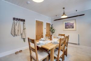 巴克斯顿Sage Cottage: Homely, Cosy Cottage with Log Burner的一间带木桌和椅子的用餐室