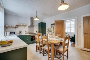 巴克斯顿Sage Cottage: Homely, Cosy Cottage with Log Burner的厨房以及带木桌和椅子的用餐室。