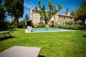 阿维尼翁Le gite de Fa nny Moulin de Tartay en Avignon的庭院中带游泳池的房子