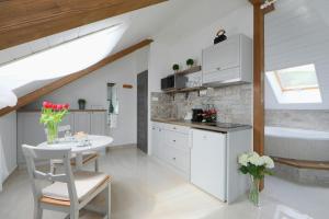 巴拉顿菲赖德Lotti Residence Romantik的白色的厨房配有桌子和浴缸