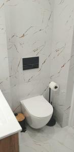 科宁VIP Room 2+2的浴室配有白色卫生间和大理石墙。