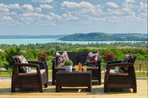 巴拉顿菲赖德Lotti Residence Romantik的庭院设有藤椅和一张桌子,享有美景。