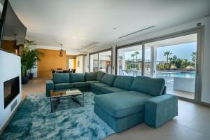 Can FurnetEs Maiols Casa B的客厅配有蓝色的沙发和电视