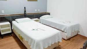 马瑙斯Mindú Park Hotel的医院房间设有两张床铺,配有白色床单