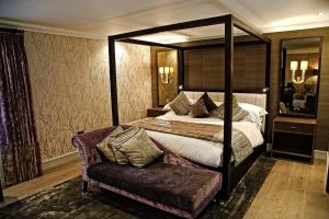 普尔福德格罗夫纳普尔福德酒店及Spa的一间卧室配有天蓬床和沙发