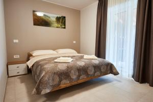 维帕瓦Posestvo Rouna - winery and apartments的一间卧室配有一张床,上面有两条毛巾