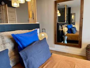 卡尔卡松Panorama Suite romantique & Spa的一间卧室配有一张带蓝色枕头和镜子的床
