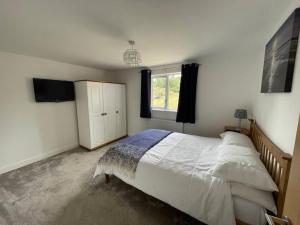 Swanton MorleyThe Lambing Lodge的一间卧室设有一张大床和一个窗户。