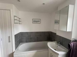 Swanton MorleyThe Lambing Lodge的带浴缸、水槽和镜子的浴室