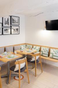瓦尔邦讷阿尔莫里酒店的用餐室配有木桌和椅子