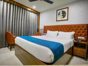 钱德加尔RONTA WORLD HOTELS的一间卧室设有一张大床和一个窗户。